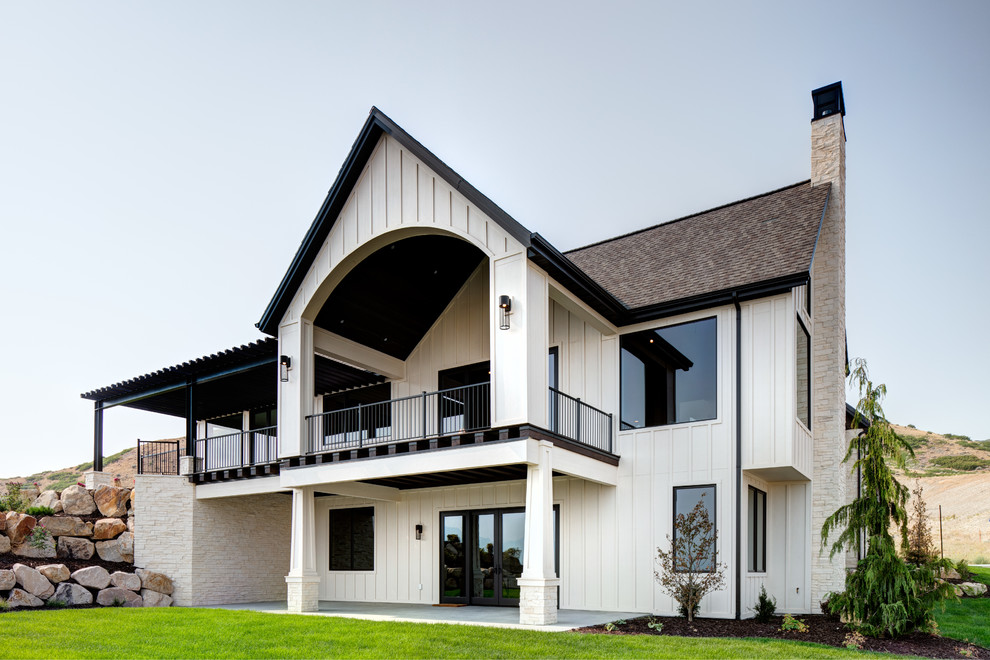 Réalisation d'une grande façade de maison beige design en panneau de béton fibré à un étage avec un toit mixte.