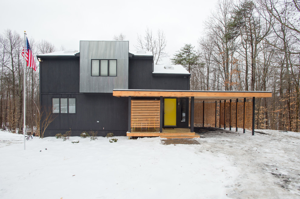 Idées déco pour une façade de maison noire contemporaine à un étage avec un revêtement mixte.
