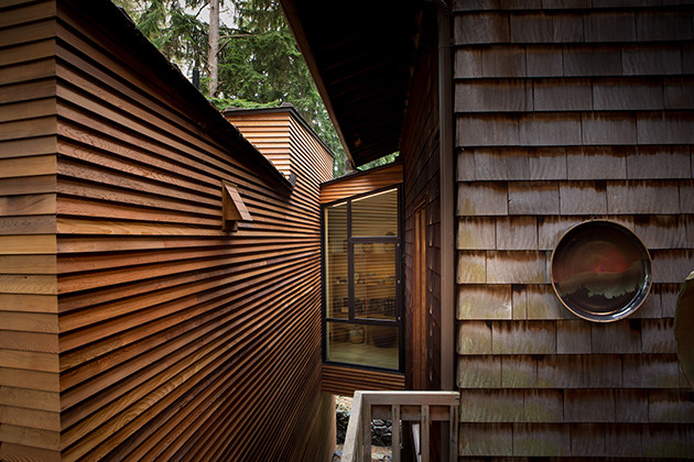 Ejemplo de fachada de casa marrón nórdica pequeña de una planta con revestimiento de madera, tejado de un solo tendido y tejado de metal