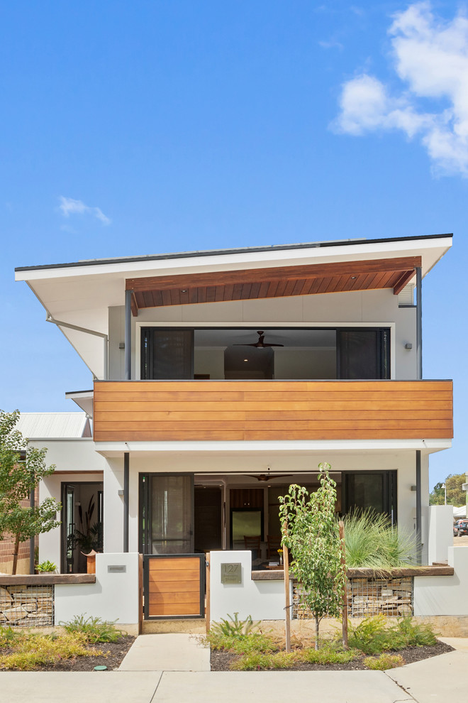 Imagen de fachada de casa blanca contemporánea de dos plantas con revestimiento de estuco y tejado de un solo tendido