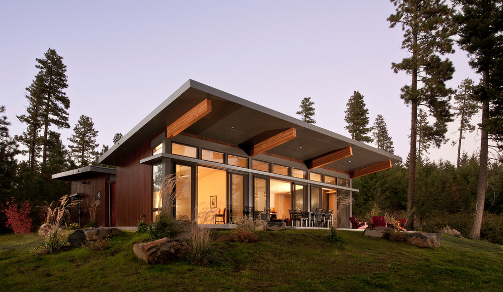 Inspiration pour une façade de maison marron design en bois de plain-pied avec un toit en appentis.