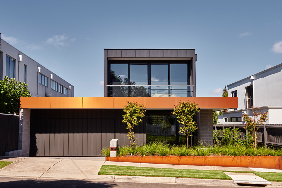 На фото: двухэтажный, серый частный загородный дом в современном стиле с облицовкой из металла и плоской крышей