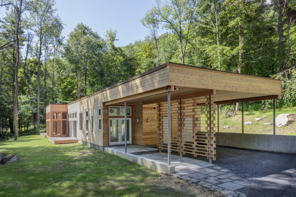 Réalisation d'une façade de maison chalet en bois de plain-pied avec un toit plat.