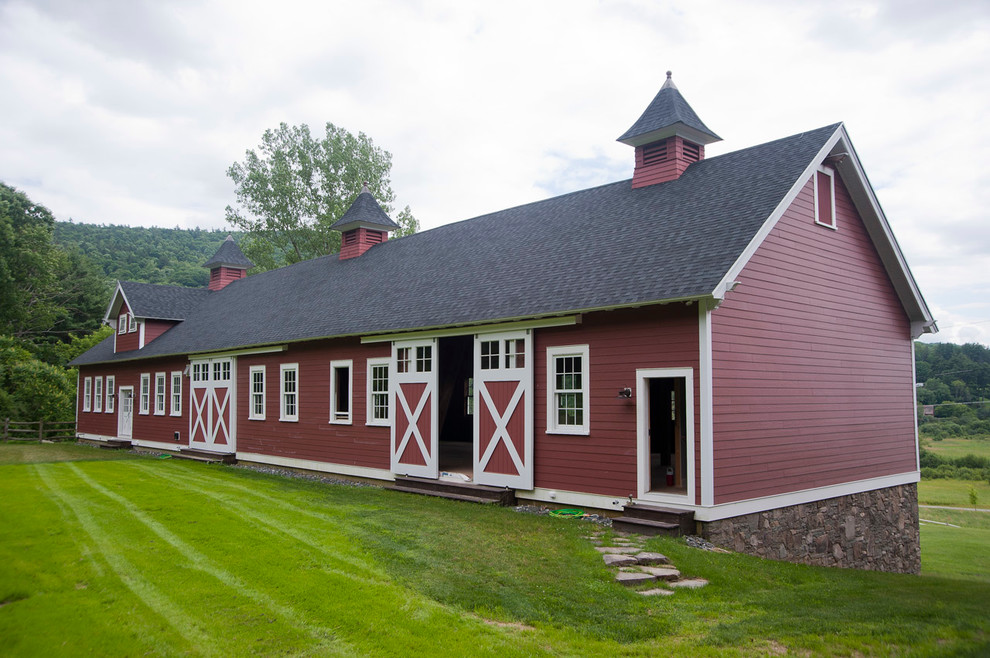 Imagen de fachada de casa roja de estilo de casa de campo grande de dos plantas con revestimiento de aglomerado de cemento, tejado a dos aguas y tejado de teja de madera