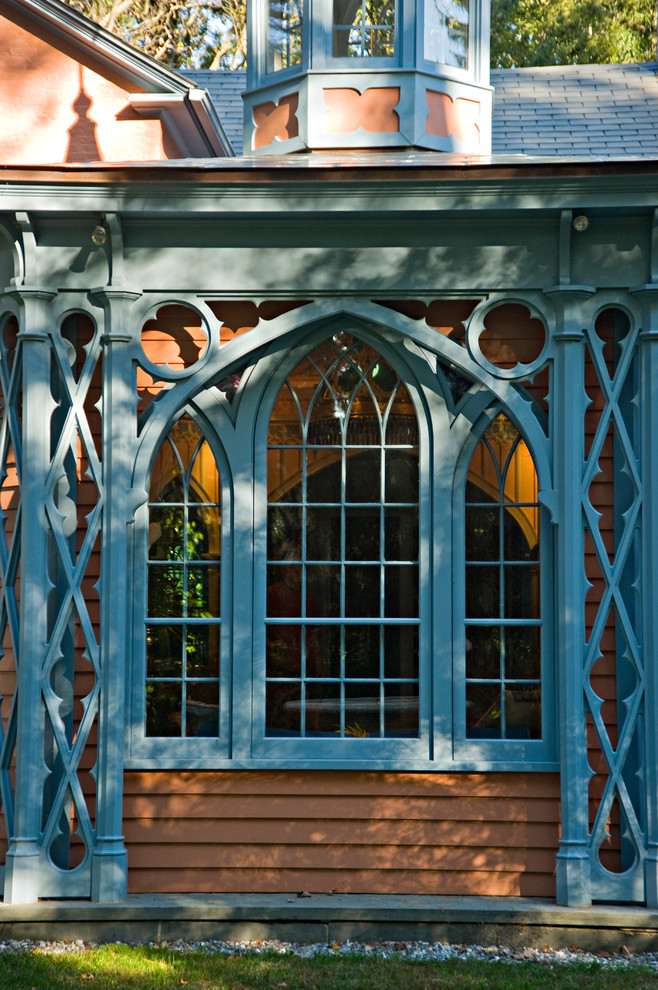 Cette photo montre une petite façade de maison marron éclectique en bois de plain-pied avec un toit à quatre pans.