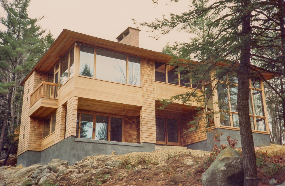 Exempel på ett stort modernt beige trähus, med tre eller fler plan och valmat tak
