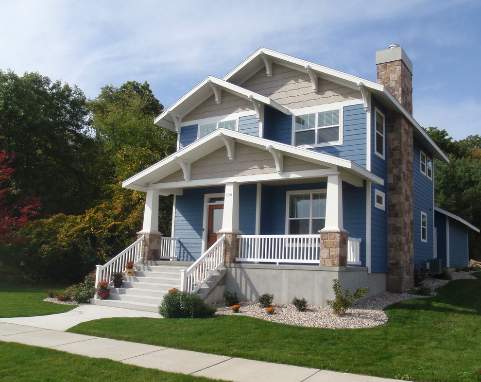 Cette image montre une grande façade de maison bleue craftsman en bois à un étage avec un toit à deux pans et un toit en shingle.