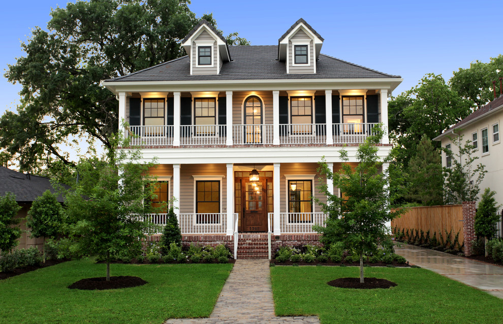 Diseño de fachada beige clásica grande de dos plantas con revestimiento de madera y tejado a cuatro aguas