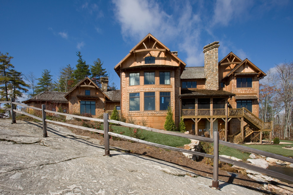 Foto della facciata di una casa grande marrone rustica a tre piani con rivestimento in legno