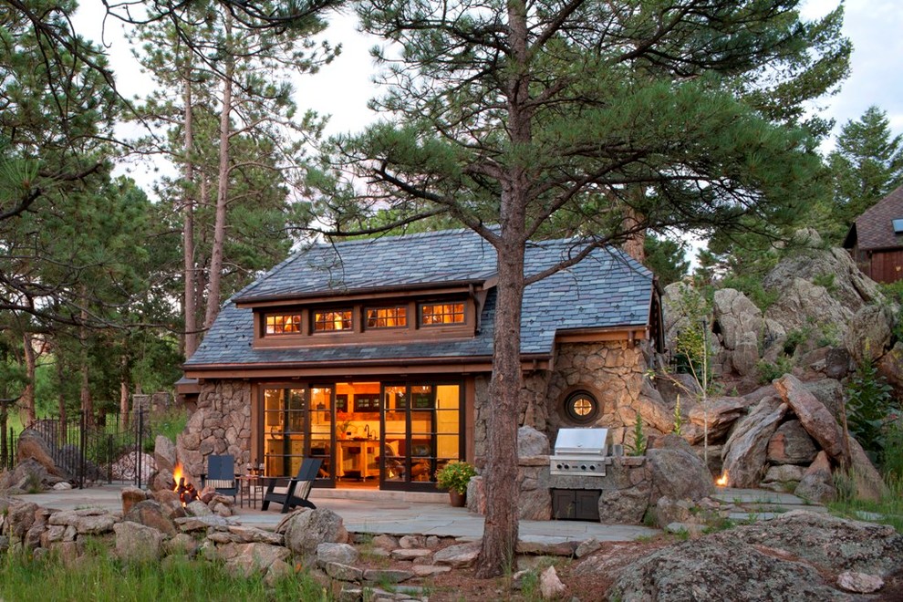 На фото: маленький, коричневый, одноэтажный частный загородный дом в стиле рустика с облицовкой из камня, крышей из гибкой черепицы и вальмовой крышей для на участке и в саду