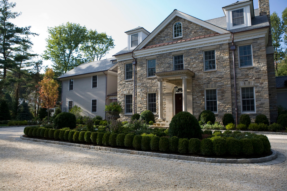 Inspiration for a large timeless gray three-story stone gable roof remodel in New York