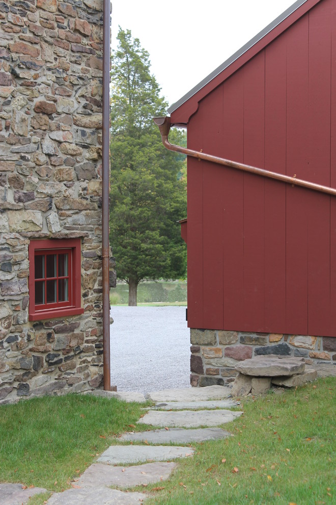 Imagen de fachada roja de estilo de casa de campo grande de dos plantas con revestimientos combinados