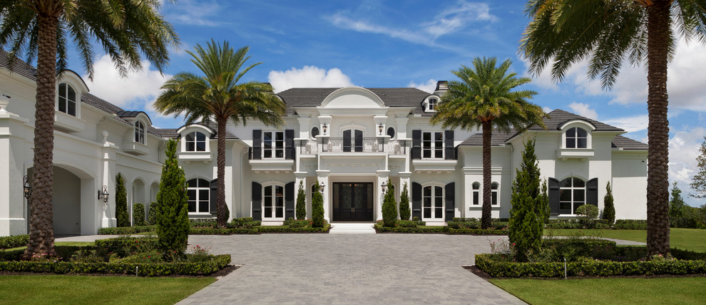 Mid-sized tuscan white two-story stucco house exterior photo in Miami with a hip roof and a shingle roof