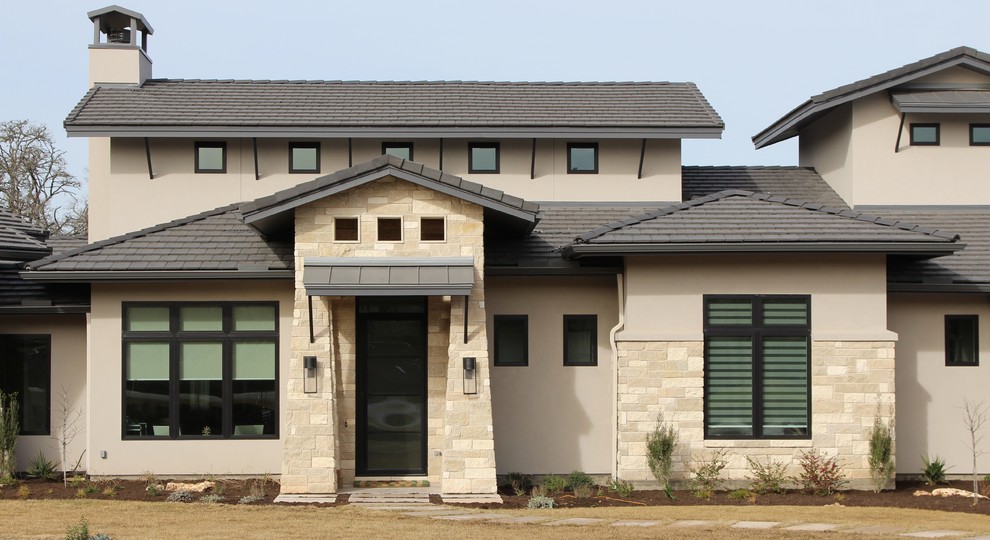 Immagine della facciata di una casa beige contemporanea a due piani di medie dimensioni con rivestimento in pietra e tetto a capanna