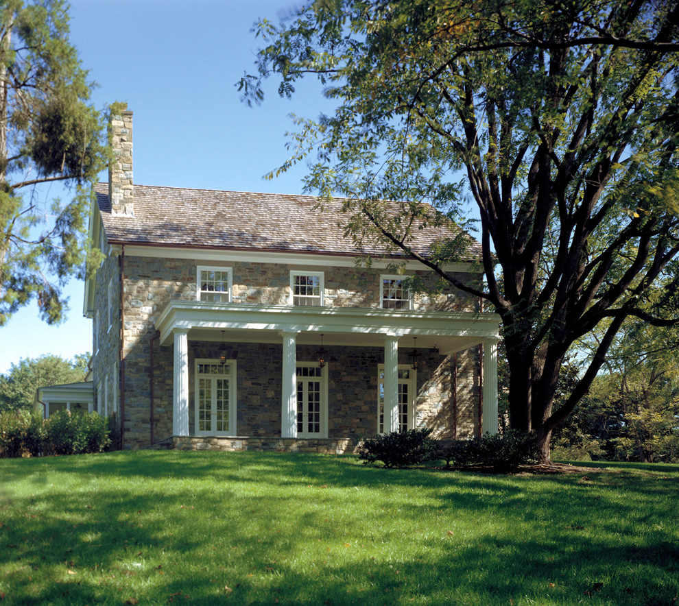 Foto della facciata di una casa classica a due piani con rivestimento in pietra