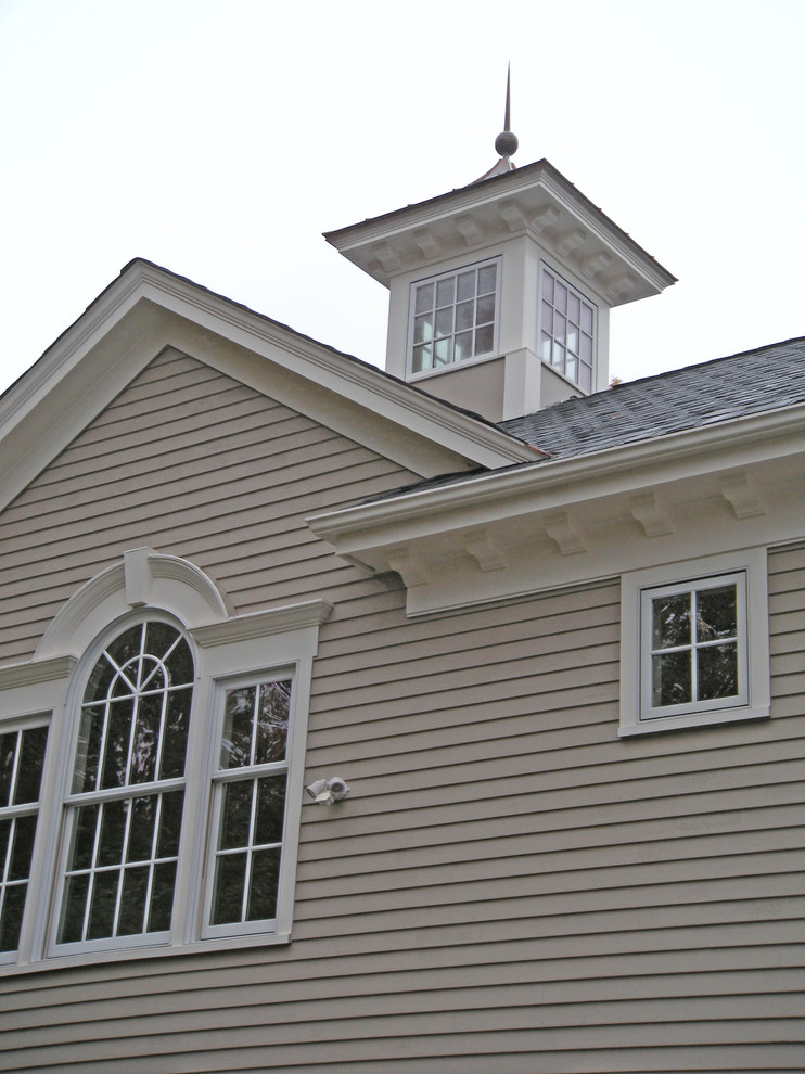 Design ideas for a beige traditional two floor house exterior in Boston with wood cladding and a pitched roof.