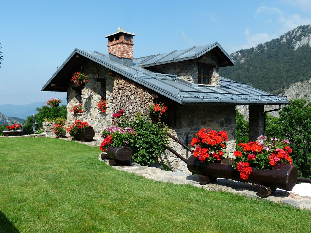 Cette photo montre une façade de maison montagne en pierre de plain-pied.