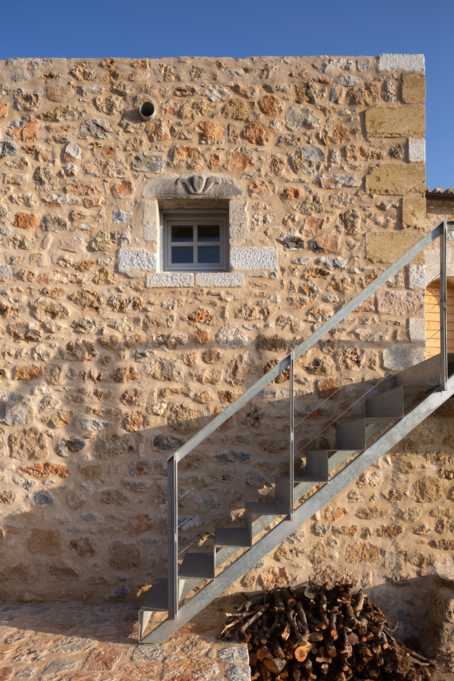 Inspiration for a mediterranean house exterior in Other with stone cladding.