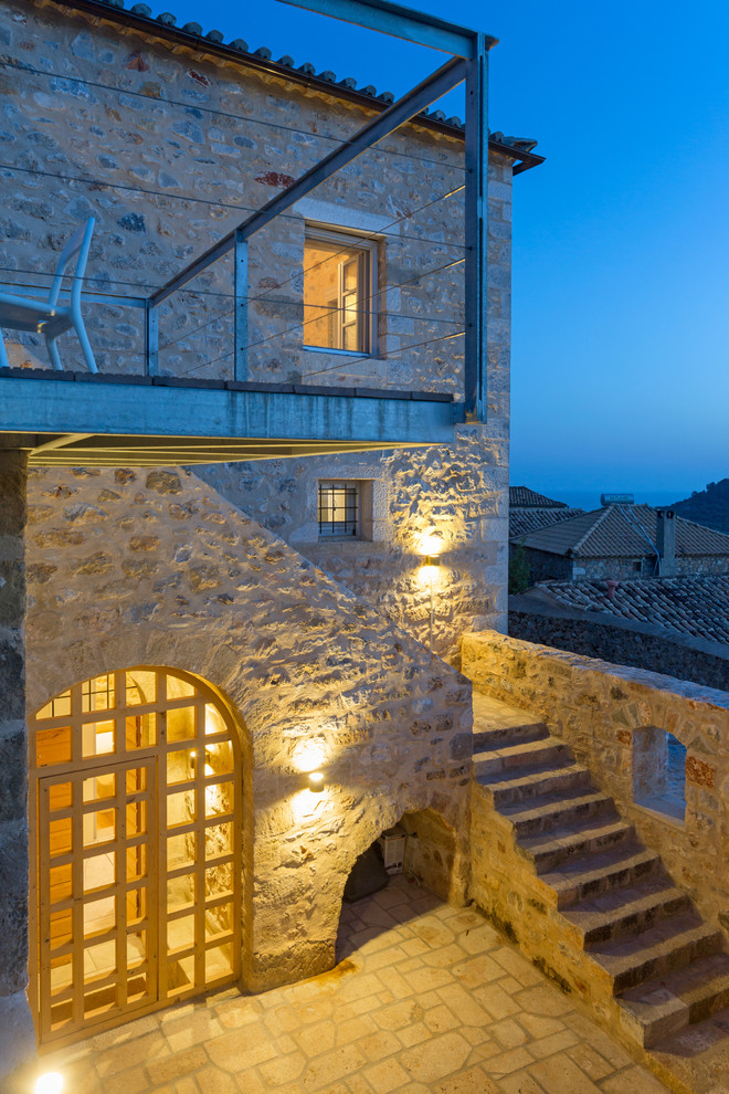 This is an example of a mediterranean house exterior in Other with stone cladding.