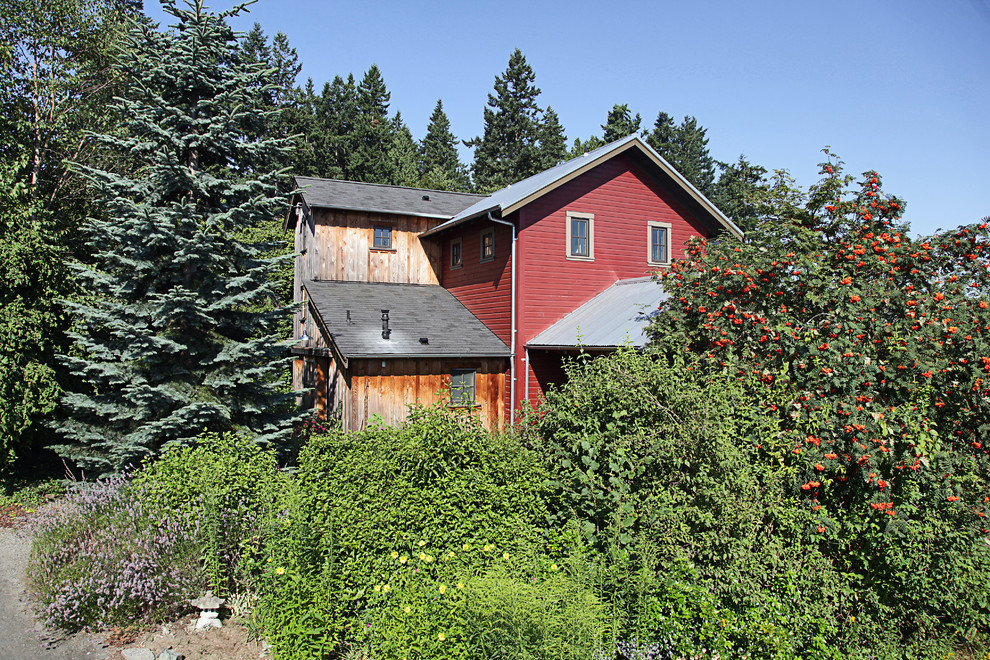 Exemple d'une façade de maison rouge éclectique avec un revêtement mixte.
