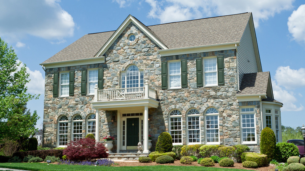 Mittelgroßes, Zweistöckiges Klassisches Einfamilienhaus mit Steinfassade, grauer Fassadenfarbe, Satteldach und Schindeldach