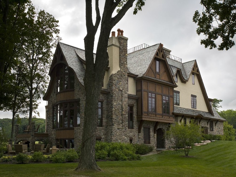 This is an example of an expansive classic render house exterior in Chicago with three floors and a pitched roof.