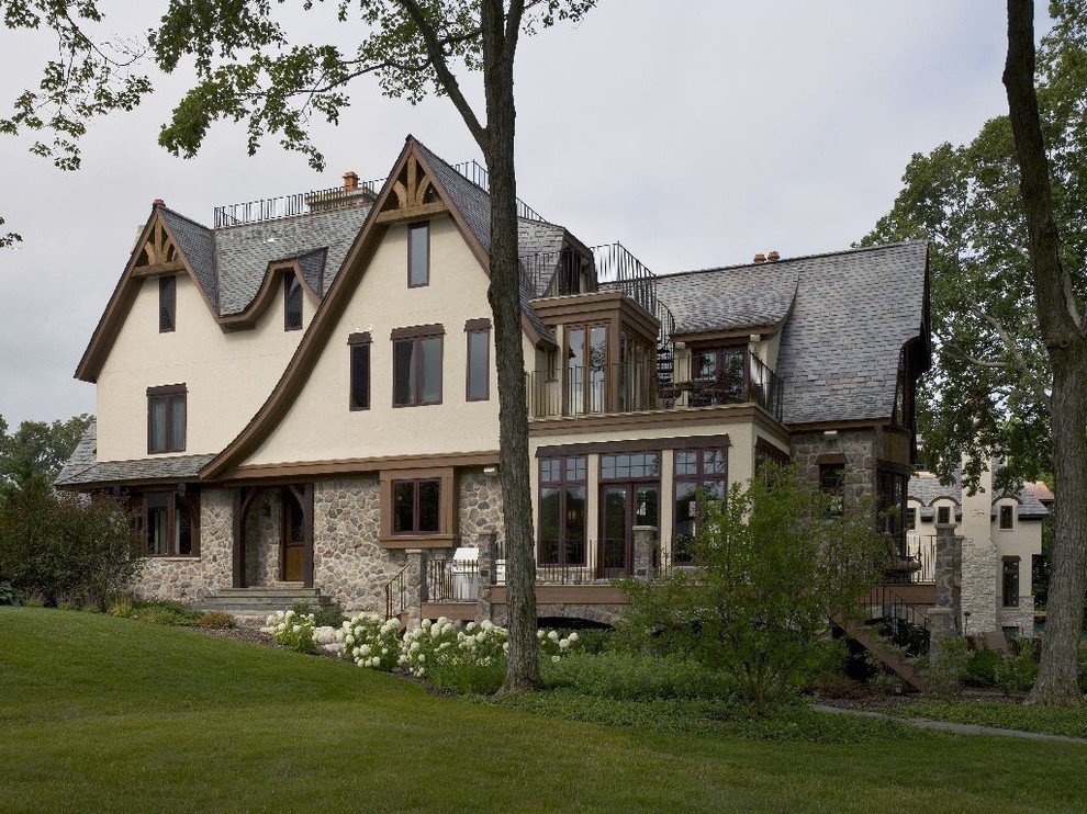 Ispirazione per la facciata di una casa ampia beige classica a tre piani con tetto a capanna e rivestimento in pietra