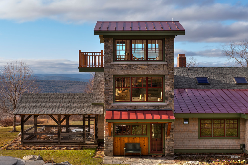 Inspiration for a rustic house exterior in Burlington with three floors and stone cladding.