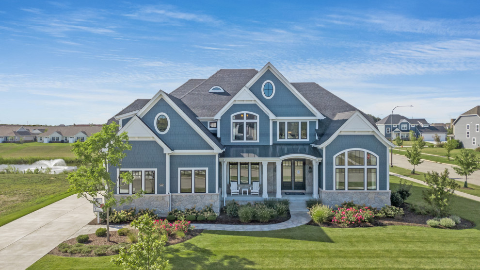 Modelo de fachada de casa azul costera extra grande de dos plantas con revestimientos combinados y tejado de varios materiales