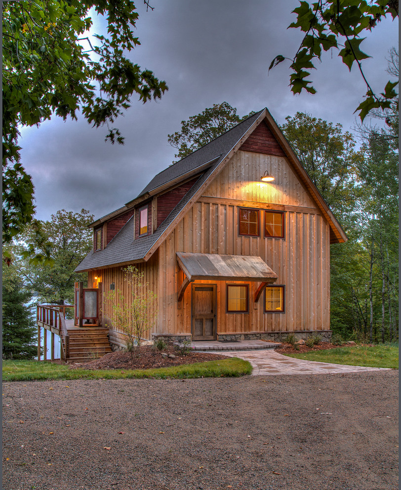 Imagen de fachada de casa nórdica de tamaño medio de tres plantas con revestimiento de madera, tejado a dos aguas y tejado de teja de madera