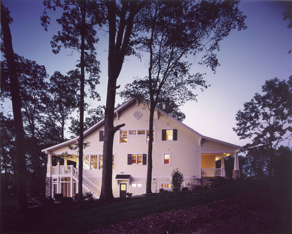 Пример оригинального дизайна: большой, трехэтажный, желтый дом в классическом стиле с комбинированной облицовкой и двускатной крышей