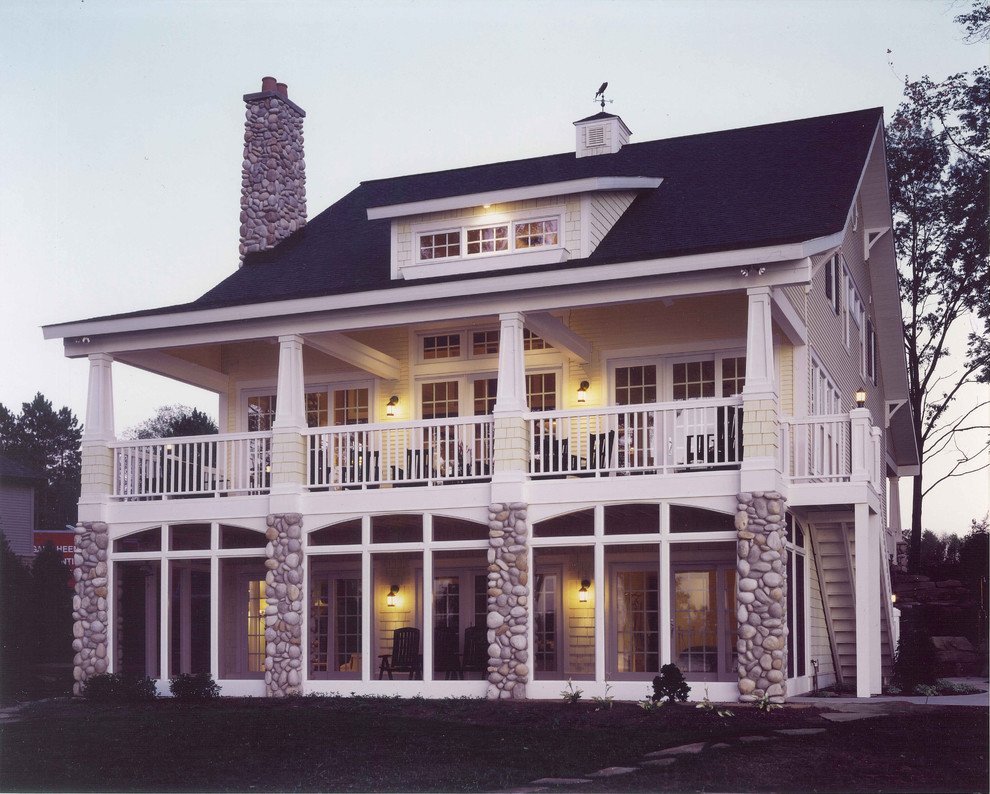 Ispirazione per la facciata di una casa grande gialla classica a tre piani con rivestimenti misti e tetto a capanna