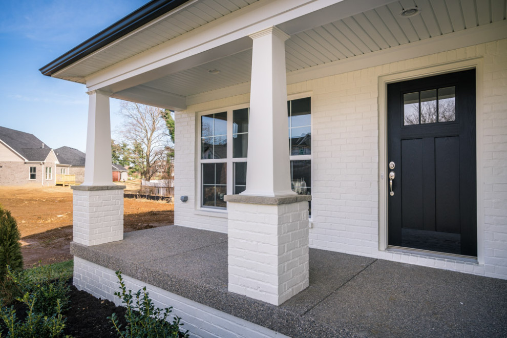 Kleines, Zweistöckiges Country Einfamilienhaus mit gestrichenen Ziegeln, weißer Fassadenfarbe und Schindeldach in Huntington