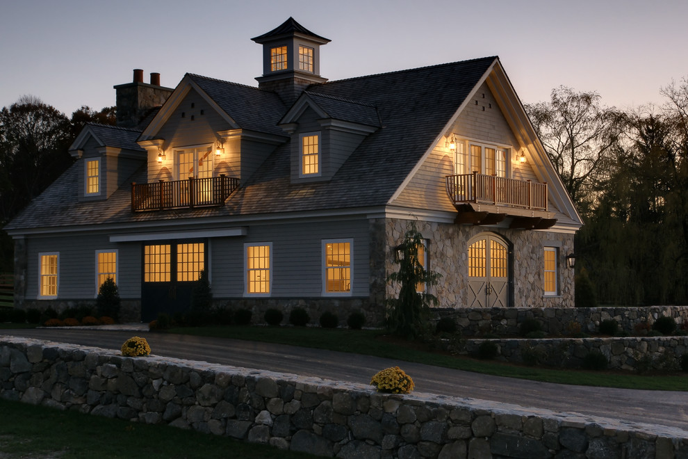 Immagine della facciata di una casa grande grigia country a due piani con rivestimento in legno e tetto a capanna