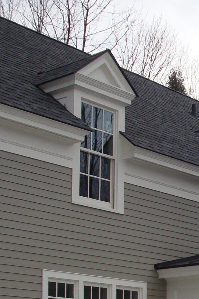 Zweistöckiges Landhausstil Haus mit Vinylfassade, weißer Fassadenfarbe und Satteldach in Burlington