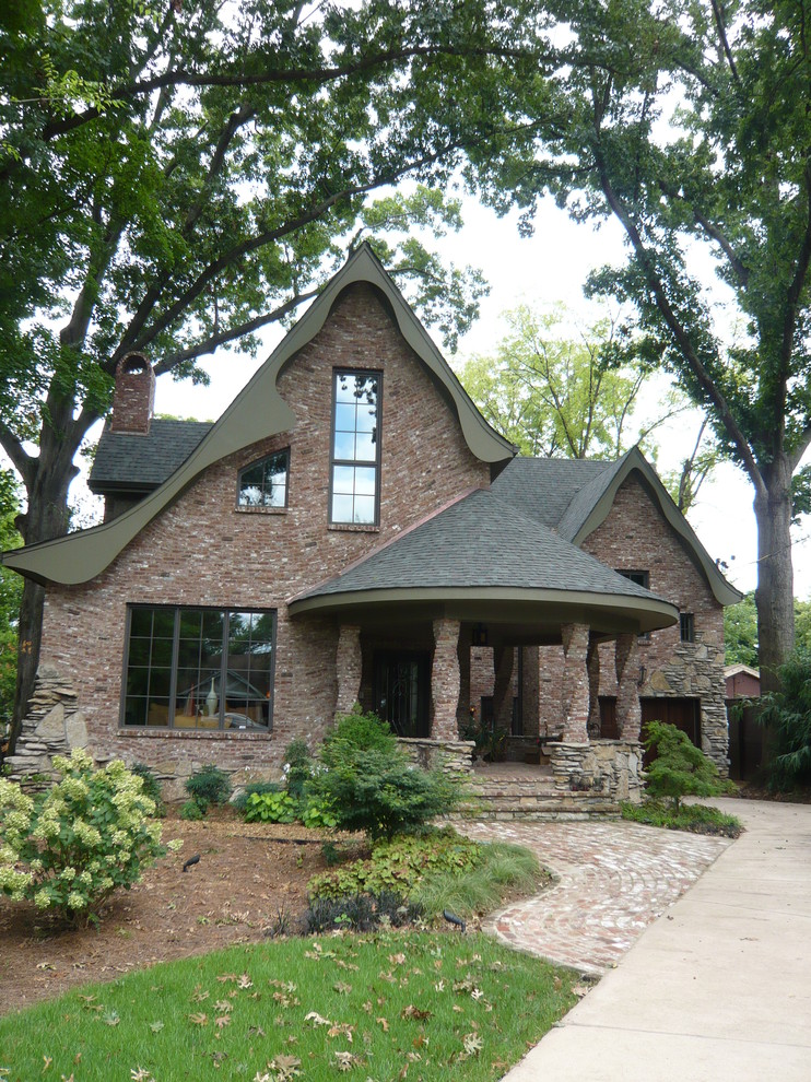 Exemple d'une façade de maison rouge éclectique en brique de taille moyenne et à un étage avec un toit à croupette.