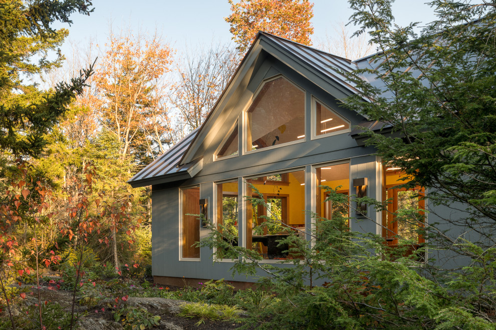 Inspiration pour une grande façade de maison verte bohème avec un toit en métal.
