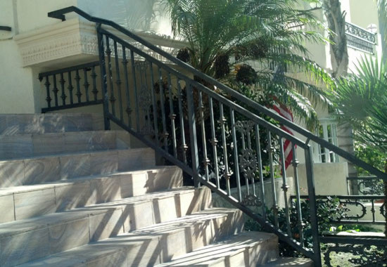ロサンゼルスにあるお手頃価格の広いモダンスタイルのおしゃれな階段 (コンクリートの蹴込み板、金属の手すり) の写真