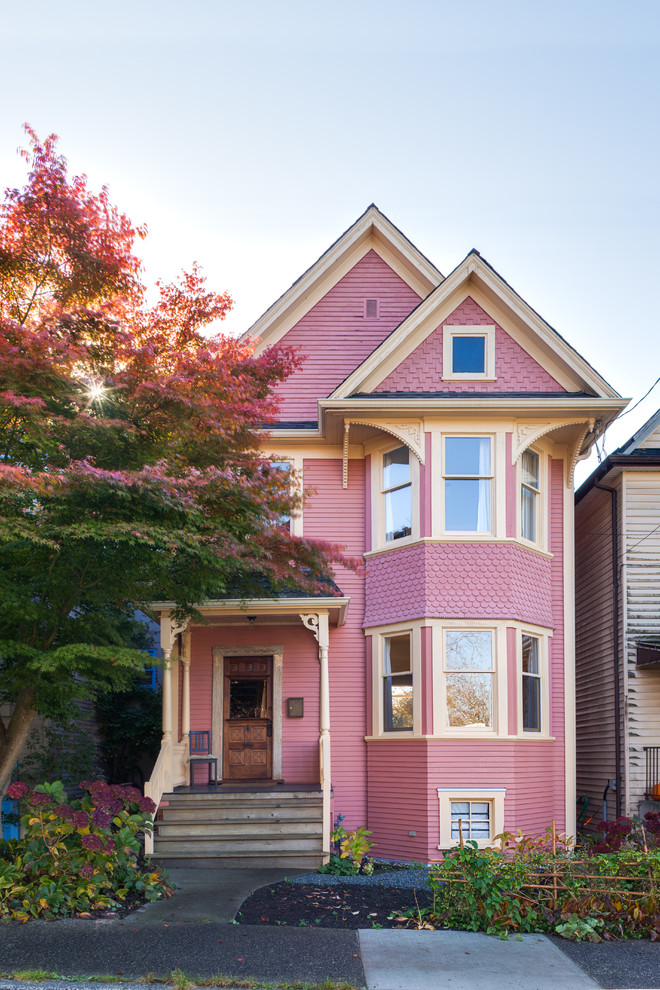 Inspiration for a classic two floor house exterior in Vancouver with a pink house.