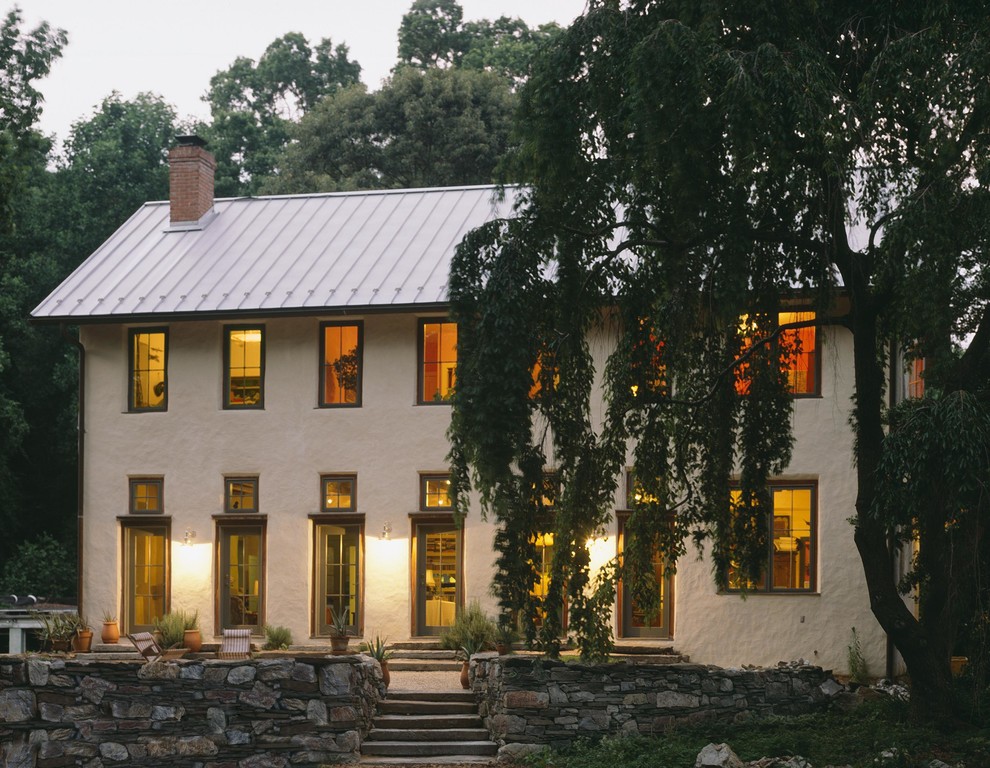 Inspiration for a mid-sized country beige two-story stucco exterior home remodel in Baltimore with a metal roof