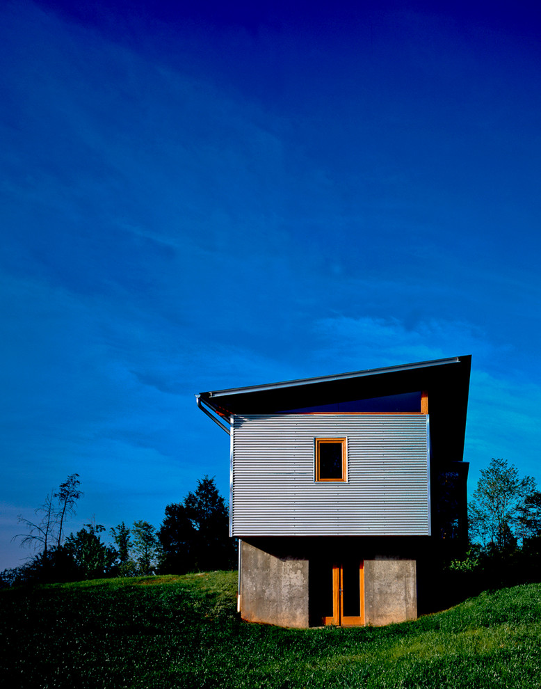 Imagen de fachada gris moderna pequeña de dos plantas con revestimiento de metal y tejado de un solo tendido