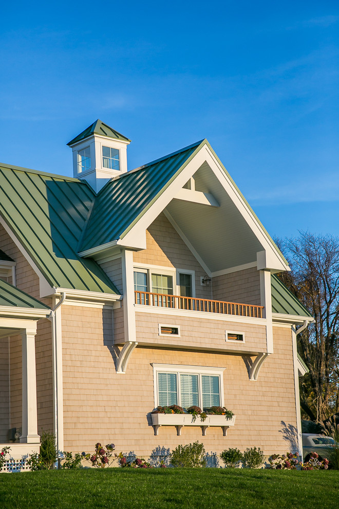 Photo of a beach style two floor house exterior in Providence with wood cladding and a pitched roof.