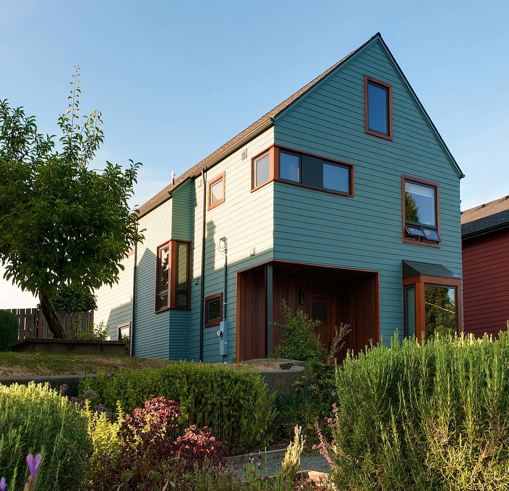 Exemple d'une façade de maison verte tendance en bois de taille moyenne et à un étage avec un toit à deux pans et un toit en shingle.