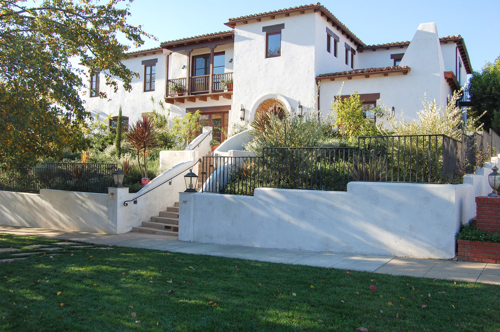 Inspiration for a large mediterranean white three-story stucco exterior home remodel in Los Angeles with a hip roof