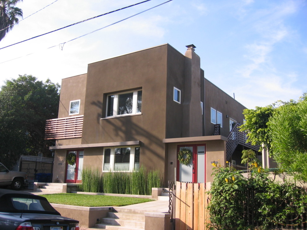 Example of a mid-sized trendy beige two-story stucco flat roof design in San Diego