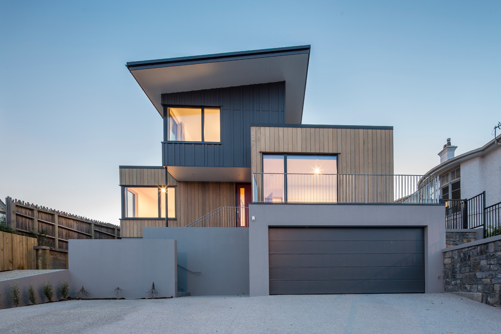 Inspiration för mellanstora moderna grå hus, med tre eller fler plan, platt tak och tak i metall