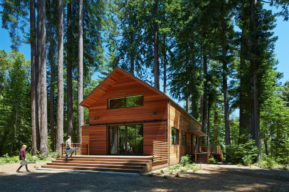 Стильный дизайн: большой, двухэтажный, деревянный, коричневый дом в современном стиле с двускатной крышей - последний тренд
