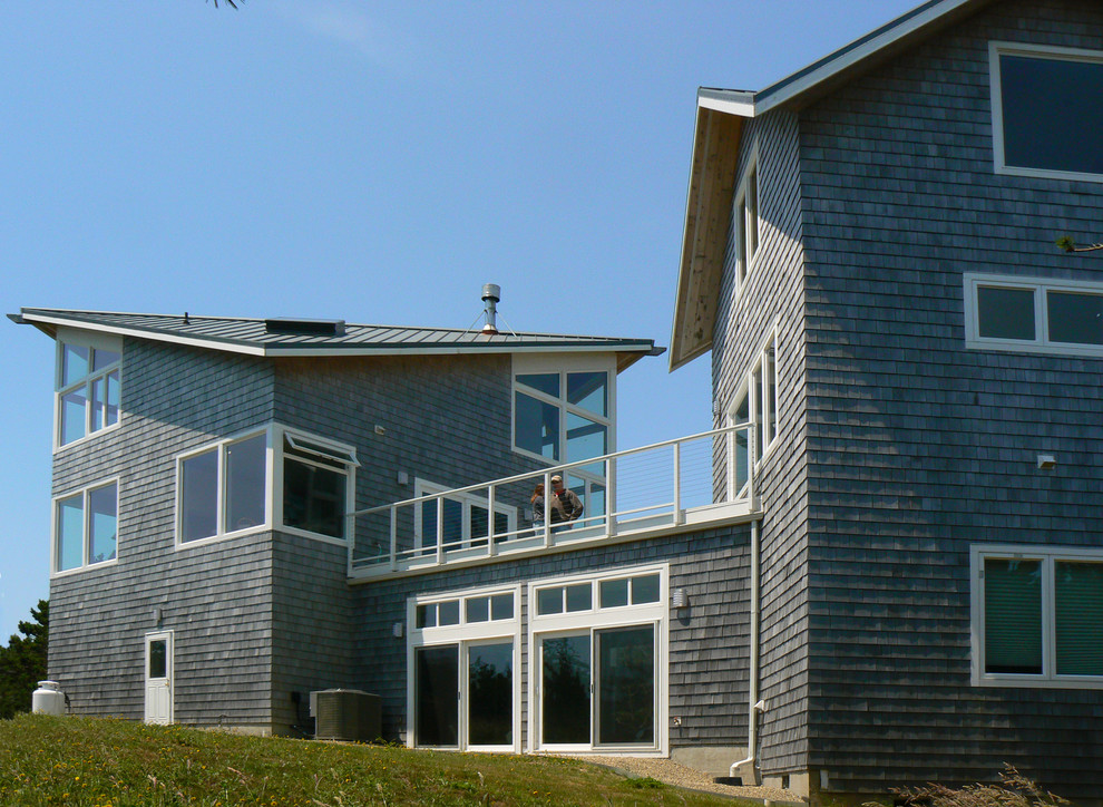 На фото: двухэтажный, деревянный, серый дом в современном стиле с