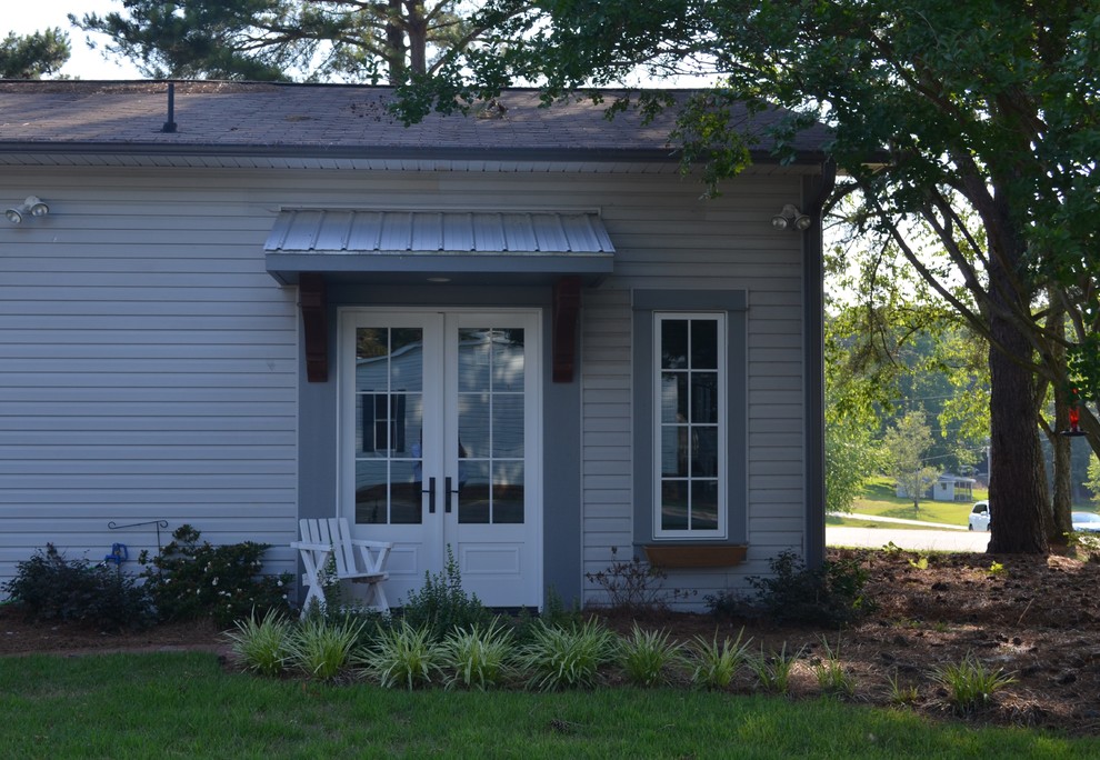 This is an example of a small and gey rustic bungalow house exterior in Atlanta with vinyl cladding.