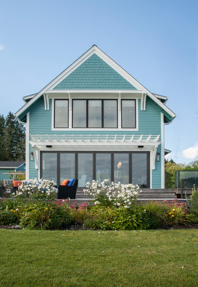 Diseño de fachada de casa verde costera de dos plantas con tejado a dos aguas
